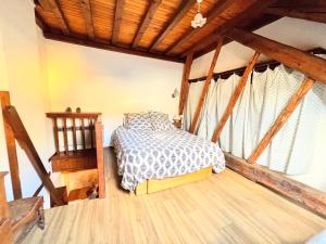 um quarto com uma cama e piso em madeira em T2 au charme authentique em Briançon