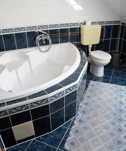 a bathroom with a tub and a toilet at Gábor apartmanok in Abádszalók