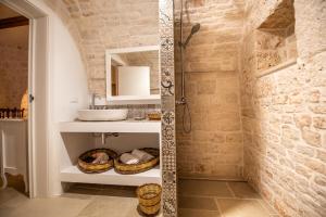 y baño con ducha y lavamanos. en Il trullo del Guelfo en Alberobello