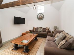 a living room with a couch and a table at The Cow Shed at Pear Tree Farm in Doncaster