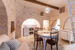 cocina y comedor con mesa y sillas en Il trullo del Guelfo en Alberobello