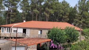una casa con techo de baldosa de color naranja en Casa do Cuco, Ribeira Sacra, en Ourense