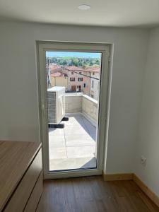 um quarto com uma porta aberta para uma varanda em Superbe maison de ville, rénovée à 15 min de Lyon em Saint-Symphorien-dʼOzon