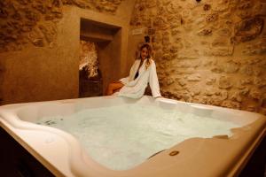 a woman is sitting in a bath tub at Antica Dimora del Tratturo Magno in Tussio