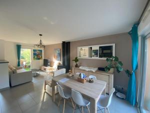 a kitchen and living room with a table and chairs at Maison avec piscine, climatisée, proche plage in Roquebrune-sur-Argens