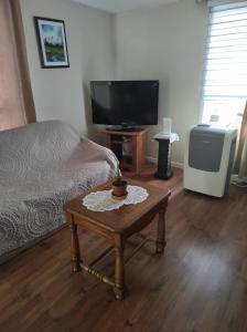 a living room with a bed and a table with a tv at Private Home in downtown Edmundston! in Edmundston