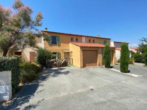 une grande maison avec un garage dans une allée dans l'établissement Maison avec piscine, climatisée, proche plage, à Roquebrune-sur Argens