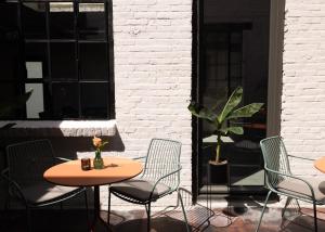 a patio with two tables and chairs and a plant at Cousins Boutique Hotel in Maastricht