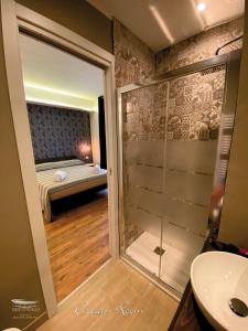 a bathroom with a shower and a bedroom with a bed at b&b Stadium room & suite in Crotone