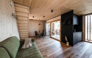 a living room with a green couch and wooden walls at Stadl Chalet oberhalb Brixen in Rosa