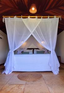 a bed with a canopy in a room at Bangalô Kauli Seadi Eco-Resort in São Miguel do Gostoso
