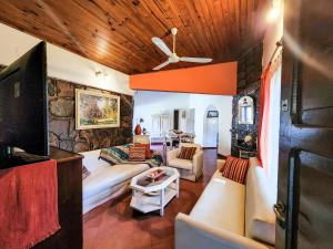 sala de estar con sofá y pared de piedra en Aco Ranch - Los Nogales - Yala in 