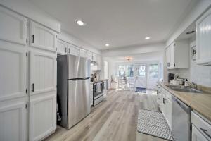 uma cozinha com armários brancos e um frigorífico de aço inoxidável em Bright and Airy Liberty Lake Abode with Backyard! em Liberty Lake