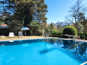 una piscina azul con sombrilla y silla en Aco Ranch - Los Nogales - Yala in 