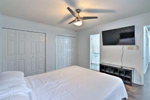 a bedroom with a white bed and a ceiling fan at Inviting Fayetteville Home with Deck and Pool! in Fayetteville