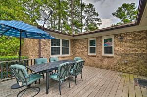 a table with chairs and an umbrella on a deck at Inviting Fayetteville Home with Deck and Pool! in Fayetteville