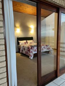 a bedroom with a bed and a sliding glass door at Wild coast Sea view House in Port Edward