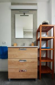 ein Badezimmer mit einer Holzkommode und einem Spiegel in der Unterkunft Piso céntrico, amplio, luminoso y familiar con garaje. in La Laguna