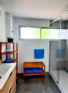ein Bad mit einer Dusche und einer Holzbank in der Unterkunft Piso céntrico, amplio, luminoso y familiar con garaje. in La Laguna