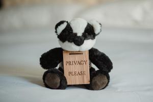 a black and white teddy bear holding a wooden sign at The Bonnie Badger in Gullane