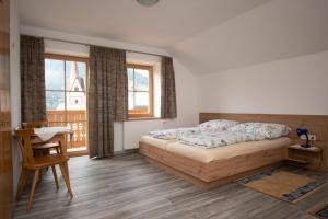 a bedroom with a bed and a desk and windows at Ferienwohnungen Lexahaus in Liesing