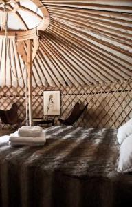 a room with a yurt with a bed and a lamp at Le Relais de Roquefereau in Penne-dʼAgenais