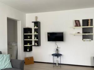 uma sala de estar com televisão numa parede branca em Tourist Apartment 1 em Piatra Neamţ
