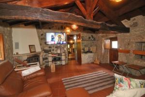 uma sala de estar com um sofá e uma lareira em Cabaninhas House em Terras de Bouro