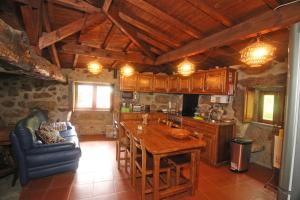 uma cozinha com uma mesa de madeira e uma sala de jantar em Cabaninhas House em Terras de Bouro