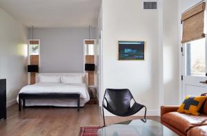 a living room with a bed and a chair at Hotel Saint Cecilia in Austin