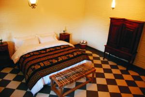a bedroom with a bed and a checkered floor at La Aguada Hotel Boutique de Montana in Coneta