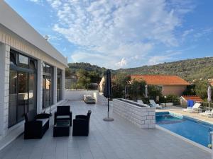 a patio with chairs and a swimming pool at Villa 4 Princesses in Vela Luka