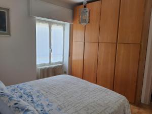 een slaapkamer met een bed, een dressoir en een raam bij CasaEndine in Ranzanico