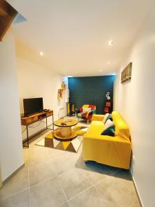 ein Wohnzimmer mit einem gelben Sofa und einem Tisch in der Unterkunft Petit Coin de Beauce in Toury