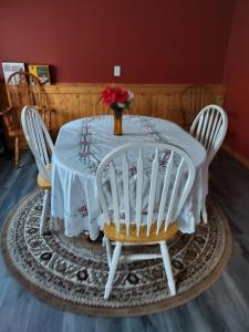 una mesa blanca con 2 sillas y un jarrón de flores en The Paradise @ Lyncott, en Lansing