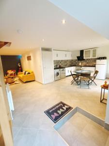 a large living room with a table and a kitchen at Petit Coin de Beauce in Toury