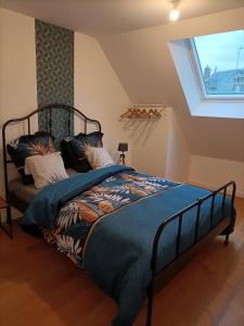 - une chambre avec un lit doté d'une couette bleue et d'une fenêtre dans l'établissement Petit Coin de Beauce, à Toury