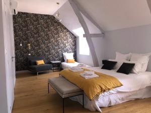 a bedroom with a large bed and a chair at Le domaine Aubazen in La Chapelle-Aubareil