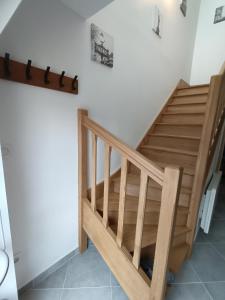 eine Holztreppe in einem Zimmer mit weißen Wänden in der Unterkunft Petit Coin de Beauce in Toury