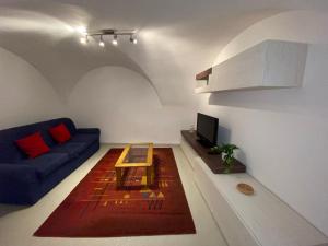 uma sala de estar com um sofá azul e uma mesa em Appartamento Degasperi em Fiavè