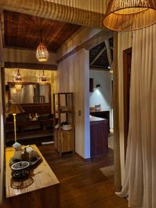 ein Wohnzimmer mit einem Tisch und einer Küche in der Unterkunft Filha Da Lua Ecolodge in Pipa