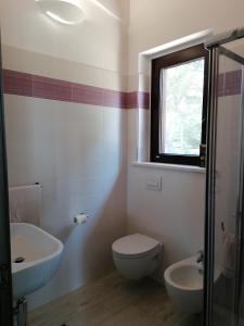een badkamer met een toilet, een wastafel en een raam bij Ortona Holidays Country House in Ortona