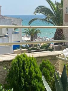 a view of a beach with palm trees and the ocean at FRENKI APARTMENT BY THE SEA in Siviri