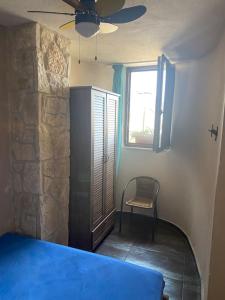 a bedroom with a blue bed and a window at FRENKI APARTMENT BY THE SEA in Siviri
