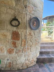 a stone wall with a clock and some stairs at FRENKI APARTMENT BY THE SEA in Siviri