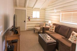 sala de estar con sofá y TV en Yellowstone Hot Springs Resort, en Gardiner