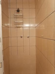 y baño con ducha de azulejos blancos. en Hospedaje PILARES DE BOCAPAN en Bocapán