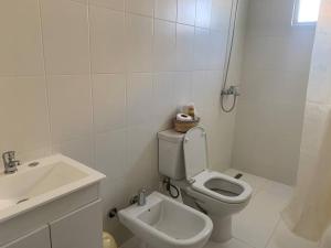 a white bathroom with a toilet and a sink at Alba II - Departamento 2 ambientes in Posadas