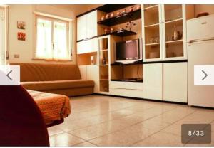 贾迪尼-纳克索斯Casa Vacanze Amici dell' Etna的客厅配有白色橱柜和电视