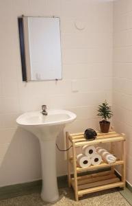 y baño con lavabo blanco y espejo. en Jardim Secreto, en São Paulo